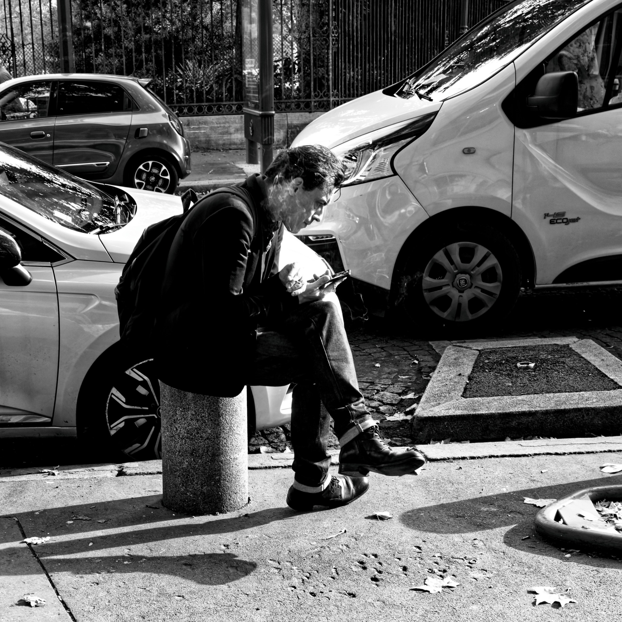 Wartender Mann an einer Straßenecke in Schwarzweiß